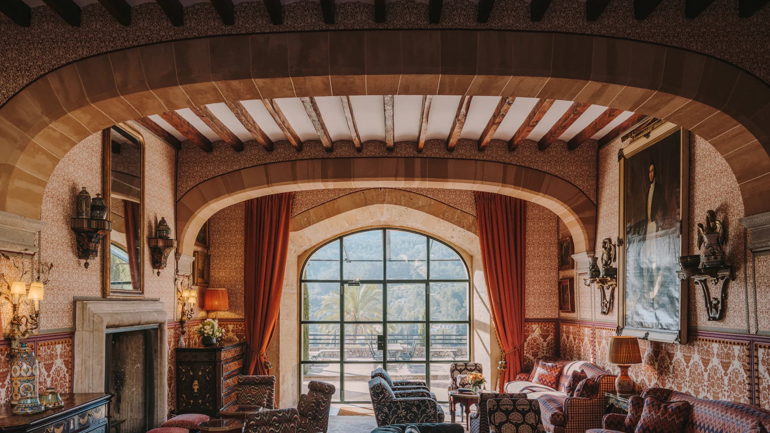 A grand sitting room with a stone arch opening onto the mountains